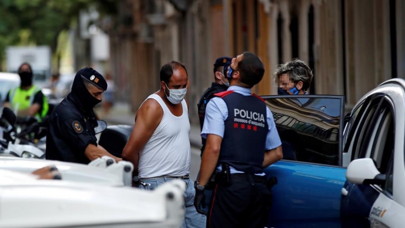 Mossos d'esquadra custodian a uno de los detenidos en la operación contra el terrorismo yihadista que llevan a cabo desde primera hora de la mañana en el distrito de Ciutat Vella de Barcelona. EFE/Toni Albir