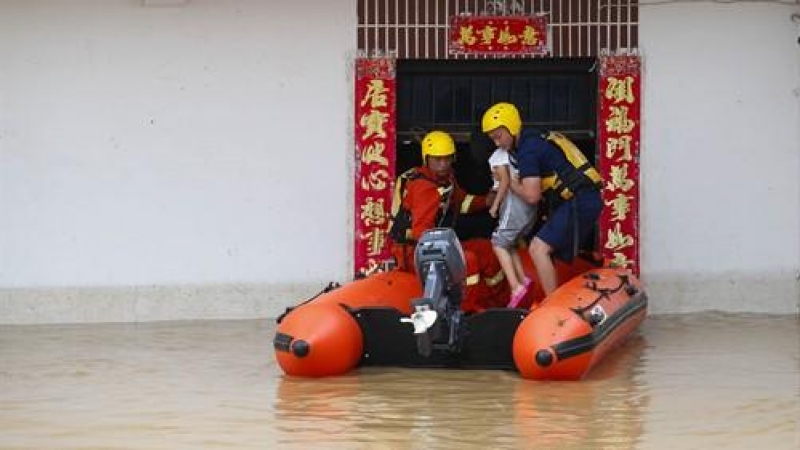 Miembros del Servicio de Rescate trabajan para evacuar a una niña atrapada por las inundaciones en Huangshan (China). /Europa Press