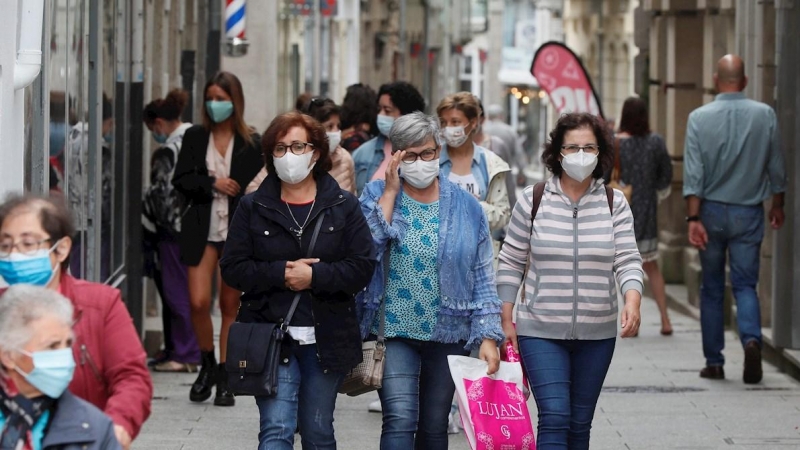 Varias personas con mascarilla caminan por la calle de Viviero, Lugo. EFE/ Eliseo Trigo