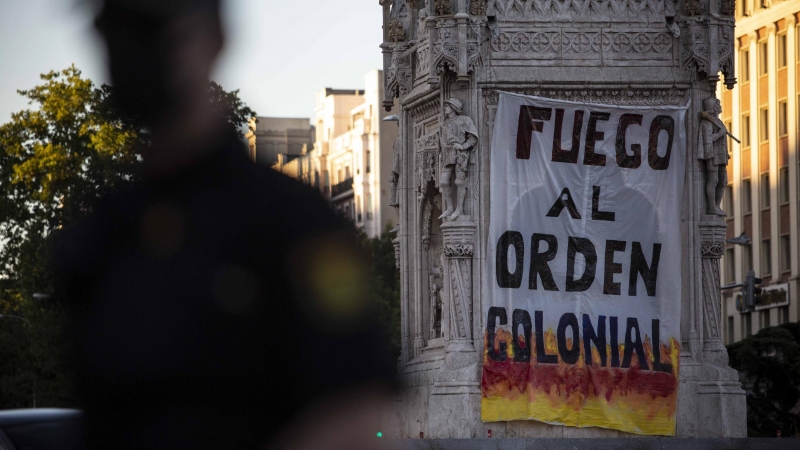 La pancarta desplegada en la estatua de Colón de Madrid por activistas antirracistas.- JAIRO VARGAS