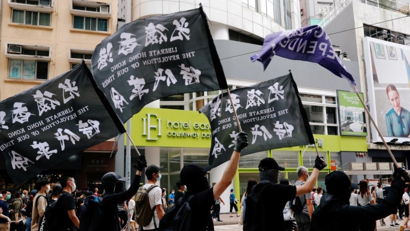 Unos manifestantes sostienen una bandera de independencia de Hong Kong mientras marcha contra la ley de seguridad nacional. REUTERS / Tyrone Siu