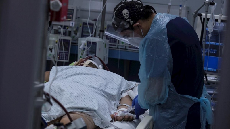 Fotografía de un sanitario que revisa el estado de un paciente afectado por covid-19. EFE/Alberto Valdés/Archivo