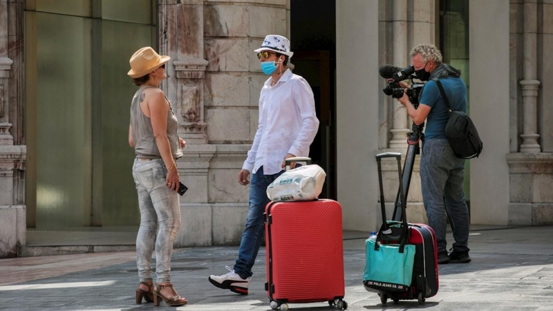 22/07/2020.- Un cámara de televisión trabaja junto a dos turistas en una calle de Oviedo, este miércoles. Una mujer y un joven del área de Oviedo que formaban parte de los contactos estrechos de dos contagiados de coronavirus que habían estado en Barcelo