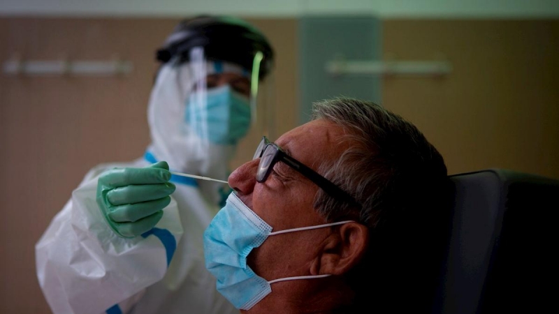 Una profesional sanitaria realiza una prueba PCR a un paciente. EFE/Enric Fontcuberta/Archivo