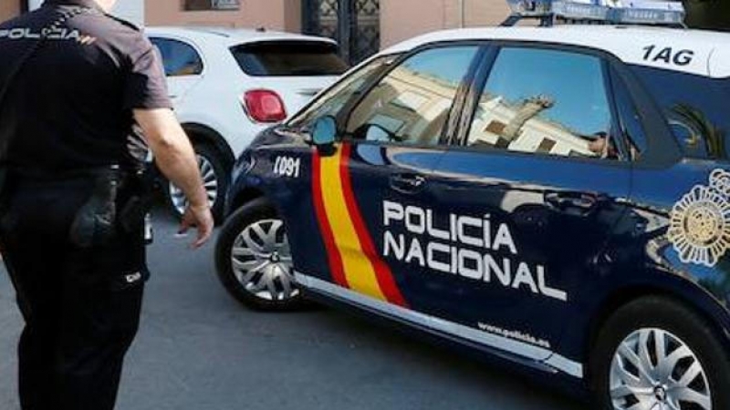 Imagen de archivo de un agente y un coche de la Policía Nacional. - EFE