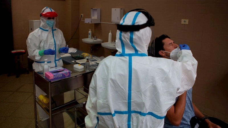 Una profesional sanitaria realiza una prueba PCR a un paciente. EFE/Enric Fontcuberta/Archivo