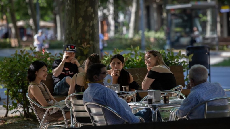 Varias personas disfrutan en la terraza de un bar de Barcelona.