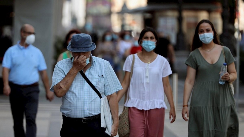 29/07/2020.- Varios ciudadanos con mascarilla pasean por una calle del centro de Madrid, este miércoles. La Comunidad de Madrid declaró obligatorio el uso de mascarilla en todos los espacios, abiertos o cerrados, no permitirá grupos de más de diez persona