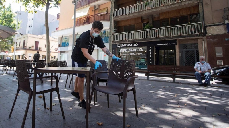 30/07/2020.- Un camarero prepara las mesas de un restaurante del centro de Gavà (Barcelona), una de las poblaciones, junto a Castelldefels, en las que el Govern ha ampliado las restricciones que afectan a Barcelona por el aumento de contagios de covid-19