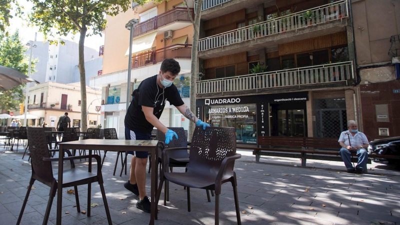 30/07/2020.- Un camarero prepara las mesas de un restaurante del centro de Gavà (Barcelona), una de las poblaciones, junto a Castelldefels, en las que el Govern ha ampliado las restricciones que afectan a Barcelona por el aumento de contagios de covid-19