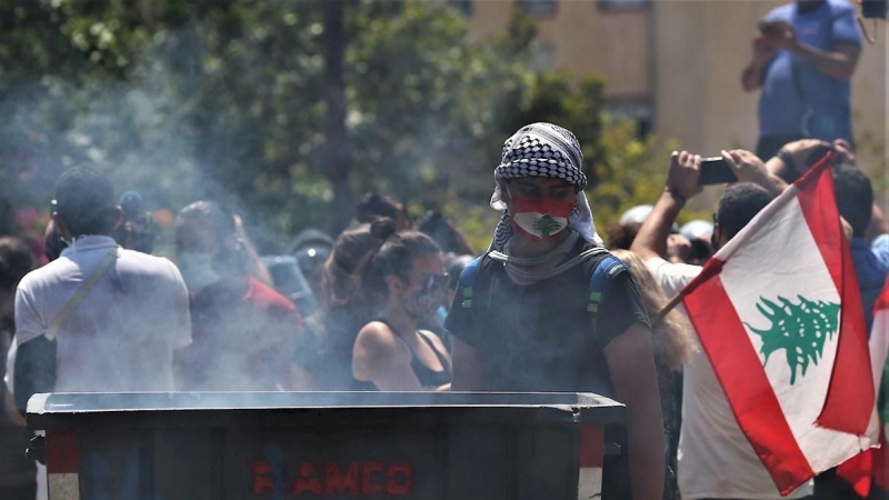 Manifestante sostiene la bandera nacional durante una protesta antigubernamental frente al Ministerio de Energía en Emile Lahoud Avenue, en el norte de Beirut, Líbano. EFE / EPA / NABIL MOUNZER