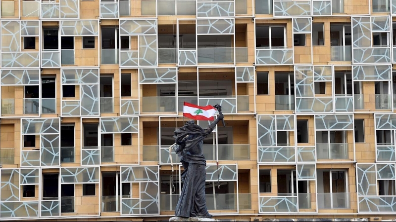 La bandera libanesa cuelga de la estatua de los Mártires en la Plaza de los Mártires en Beirut, Líbano. /EFE/EPA/WAEL HAMZEH