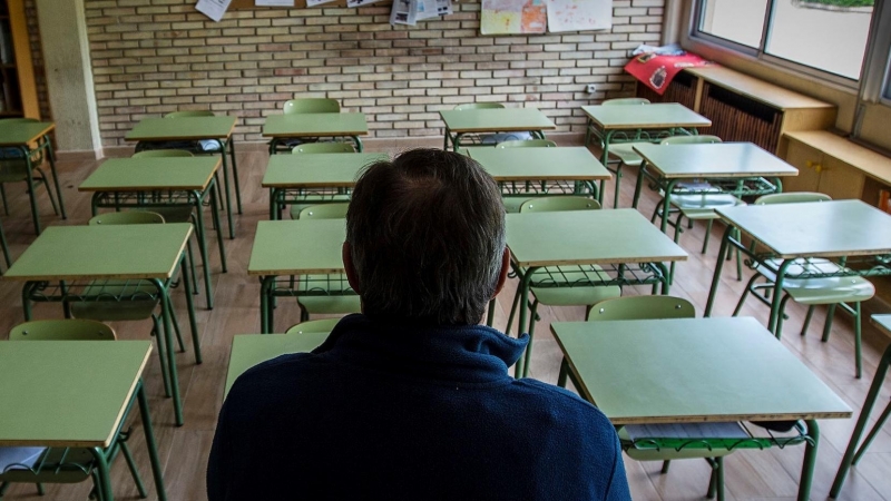 Un profesor en una clase vacía de un colegio. EFE/ Paco Santamaria/Archivo