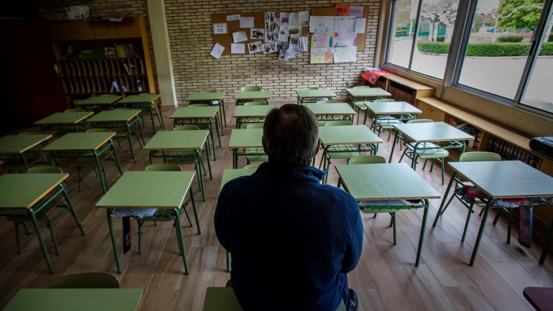 Un profesor en una clase vacía de un colegio. EFE/ Paco Santamaria/Archivo