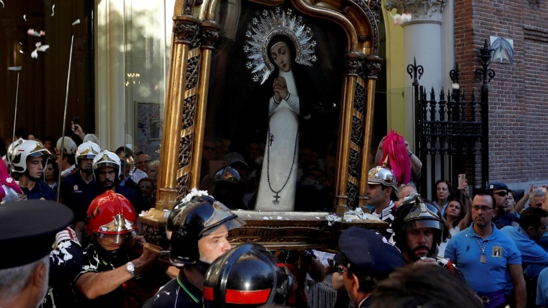 Bomberos sacan al exterior el cuadro de la Virgen de la Paloma, durante la tradicional procesión de la Virgen de la Paloma que tiene lugar en el centro de Madrid. EFE/ David Fernández