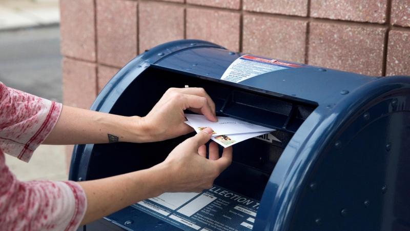 Una persona deposita cartas en un buzón de cobranza del Servicio Postal de EE. UU. (USPS) en Filadelfia, Pensilvania, EE. UU., 14 de agosto de 2020. / REUTERS / Rachel Wisniewski