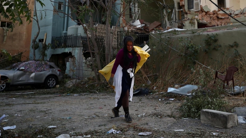 Una mujer caminando por los restos de la explosión en Beirut. / REUTERS