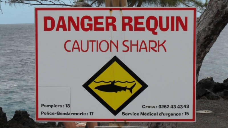 Cartel alertando del peligro de tiburones en una playa de la isla de La Reunión, Francia. / Tybo2