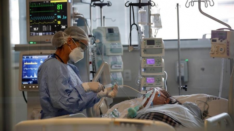Una médica observa a un paciente en la Unidad de Cuidados de Intensivos / EFE /Sebastiao Moreira