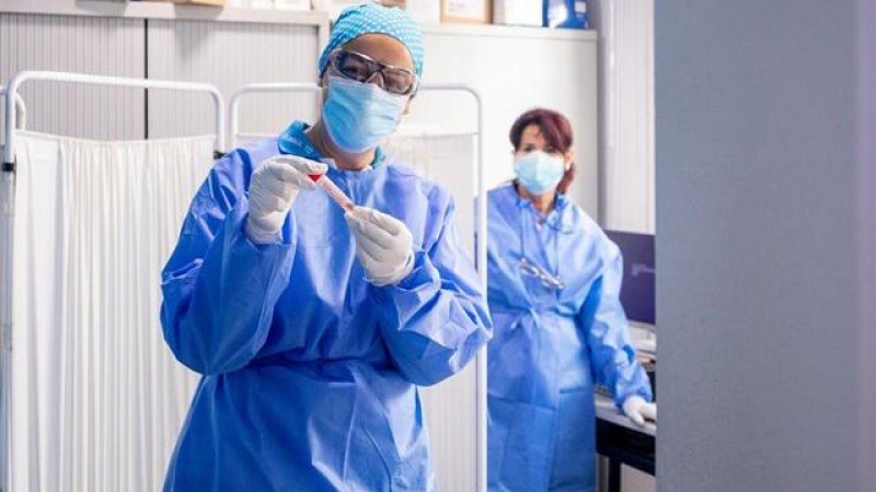 Una trabajadora sanitaria protegida sostiene una de las probetas utilizadas para la realización de tests PCR en el Centro de Especialidades Carabanchel Alto / Ricardo Rubio / Europa Press