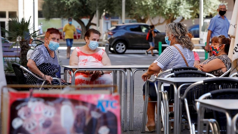 Una vecinas descansan en la terraza de un bar del barrio de la Pastoreta de Reus (Tarragona) donde este lunes se han reanudado los cribados masivos de PCR a los vecinos. /EFE