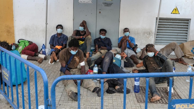 Las personas migrantes que acaban de sortear la valla de Melilla esperan a las afueras de la Plaza de Toros./ José Palazón