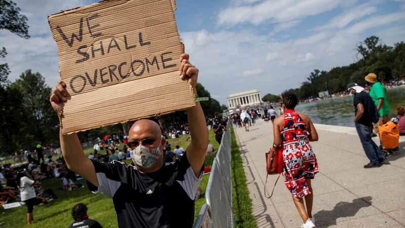 Activista sostiene un cartel 'We shall overcome' ('Nosotros venceremos') durante la marcha antirracista en Washington. /EFE/EPA/SHAWN THEW