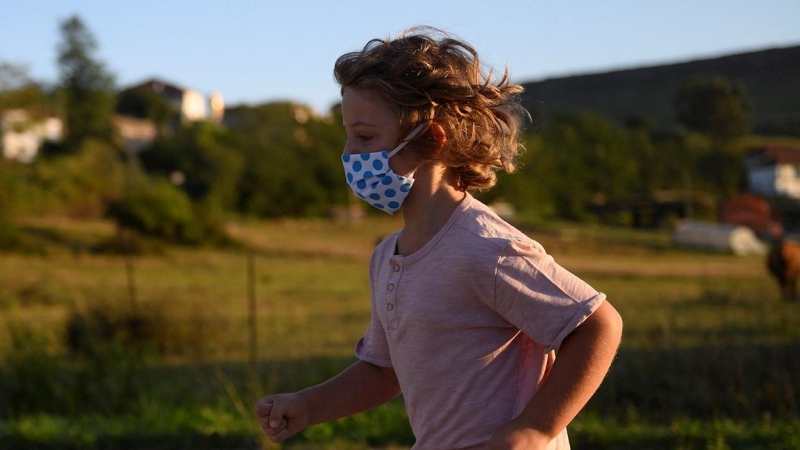 Un niño con mascarilla para protegerse del coronavirus, en Suances (Cantabria). PEDRO PUENTE HOYOS (EFE)