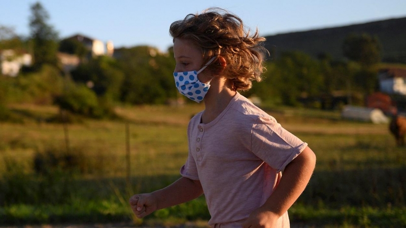 Un niño con mascarilla para protegerse del coronavirus, en Suances (Cantabria). PEDRO PUENTE HOYOS (EFE)