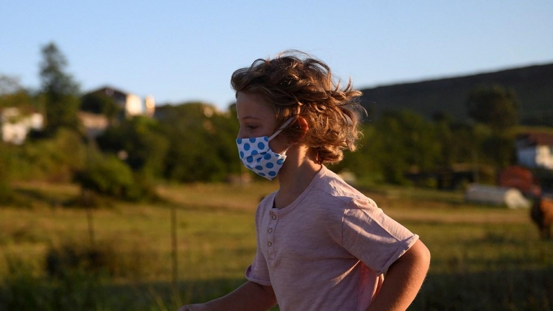 Un niño con mascarilla para protegerse del coronavirus, en Suances (Cantabria). PEDRO PUENTE HOYOS (EFE)