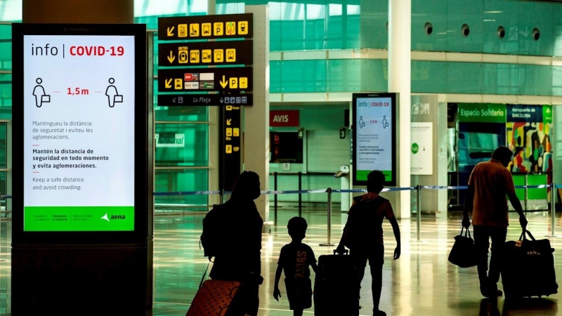 Viajeros con máscaras sanitarias caminan por la Terminal 1 del aeropuerto Josep Tarradelles - El Prat, en Barcelona. EFE/ Enric Fontcuberta