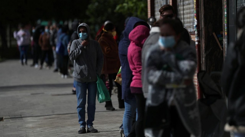 Personas haciendo cola en la calle para recibir alimentos, como ayuda de una asociación vecinal en Madrid. REUTERS/Susana Vera