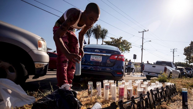 Una persona coloca una vela donde Dijon Kizzee recibió 20 disparo de dos agentes en Los Ángeles. EFE / EPA / ETIENNE LAURENT