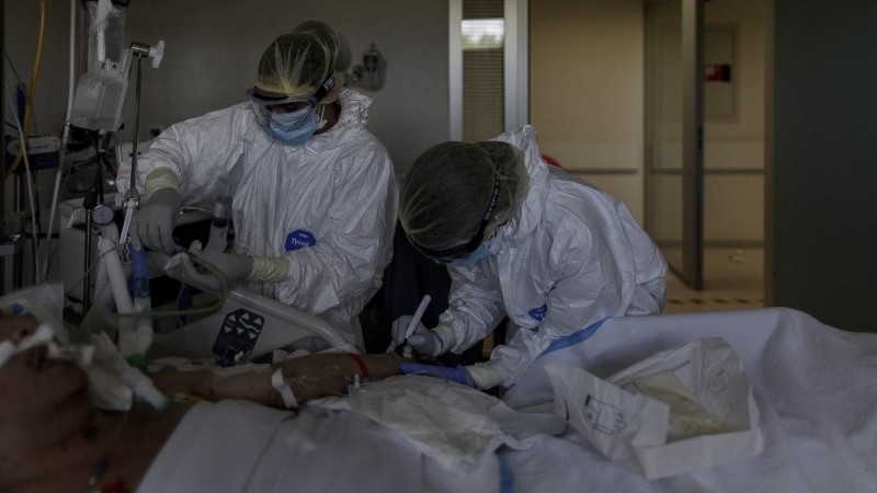 Personal sanitario totalmente protegido atiende a un paciente ingresado en la Unidad de Cuidados Intensivos del Hospital Infanta Sofía en San Sebastián de los Reyes (Madrid). Eduardo Parra / Europa Press