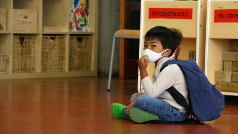 Un alumne d'infantil de l'Institut Escola Costa i Llobera, assegut amb mascareta, esperant per entrar a l'aula. Blanca Blay