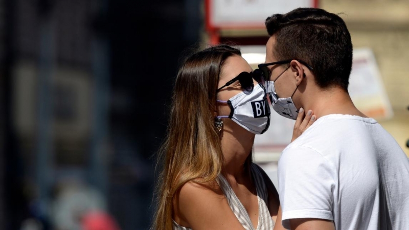 Una pareja con mascarilla mientras se besan. Europa Press / Archivo