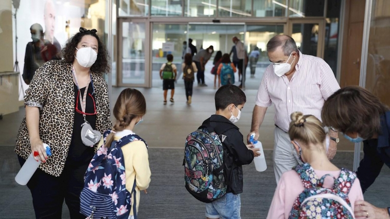 Personal del colegio Aldapeta María Ikastetxea aplica este lunes gel hidroalcohólico a los alumnos. EFE/ Juan Herrero