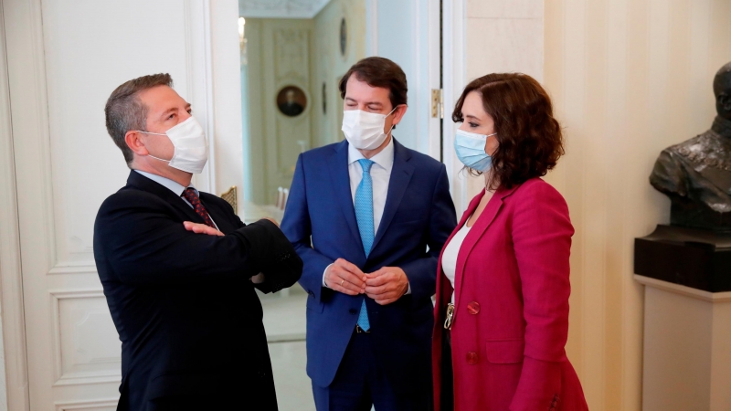 La presidenta de la Comunidad de Madrid, Isabel Díaz Ayuso (d), conversa con sus homólogos de Castilla y León, Alfonso Fernández Mañueco (c), y de Castilla-La Mancha, Emiliano García-Page, durante la reunión que mantuvieron para coordinar actuaciones conj