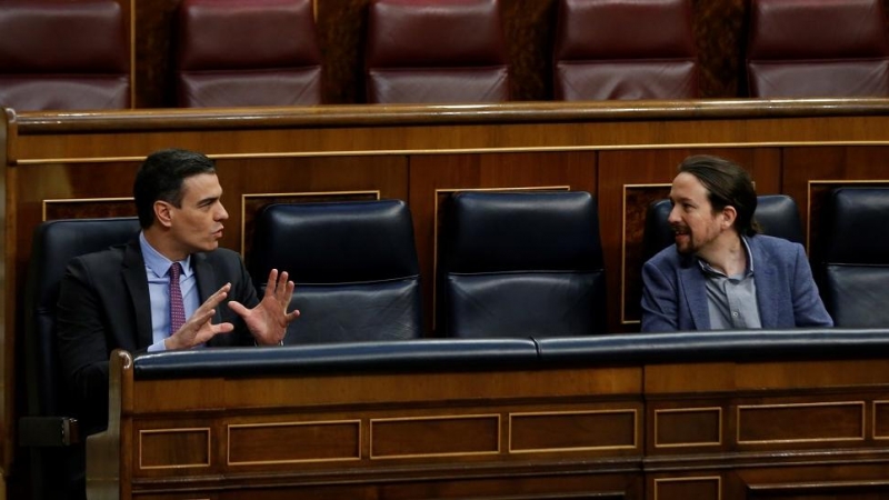 El presidente del Gobierno, Pedro Sánchez, conversa con el vicepresidente segundo, Pablo Iglesias,  durante una sesión de control al Gobierno en el Congreso de los Diputados. E.P./Pool