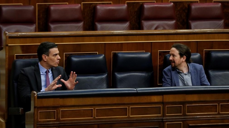 El presidente del Gobierno, Pedro Sánchez, conversa con el vicepresidente segundo, Pablo Iglesias,  durante una sesión de control al Gobierno en el Congreso de los Diputados. E.P./Pool