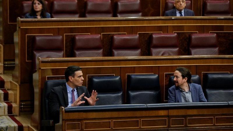 El presidente del Gobierno, Pedro Sánchez, conversa con el vicepresidente segundo, Pablo Iglesias,  durante una sesión de control al Gobierno en el Congreso de los Diputados. E.P./Pool