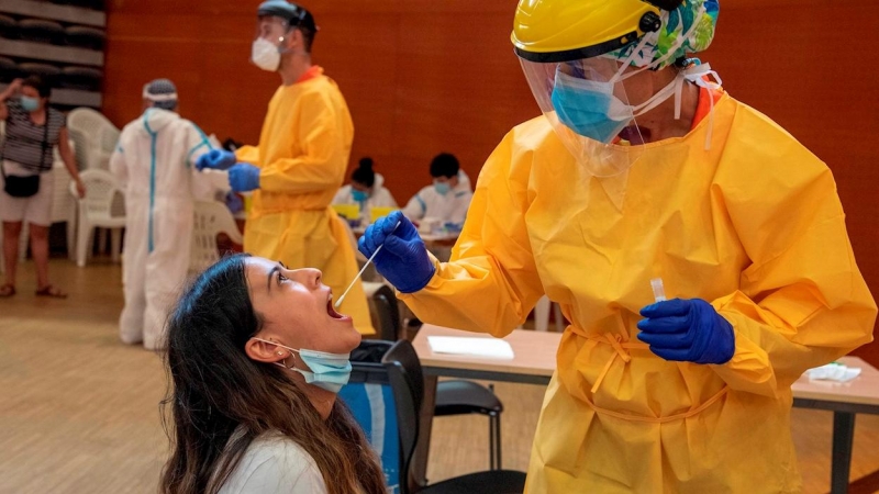 Una joven es atendida por un profesional sanitario en un Centro Cívico de barrio de Balàfia LLeida, donde el departamento de Salud realiza cribados masivos de PCR. EFE/ Ramon Gabriel/Archivo