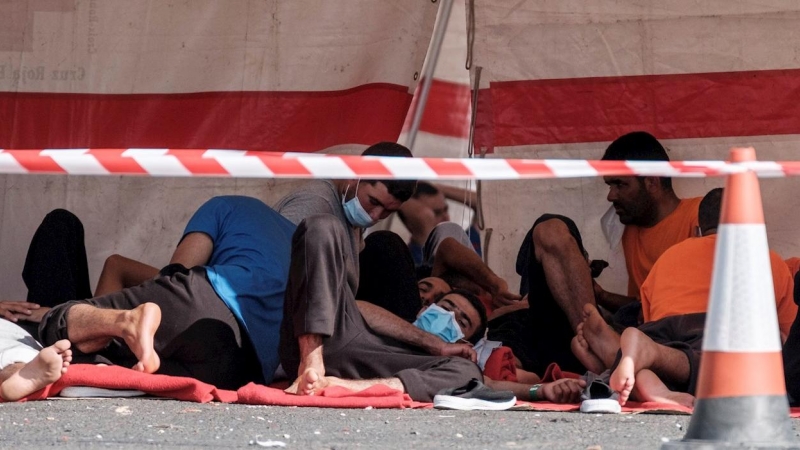 Un grupo de migrantes magrebíes, en el suelo del muelle del puerto de Arguineguín, en Gran Canaria, tras ser rescatados por Salvamento Marítimo.- EFE/ Ángel Medina G.