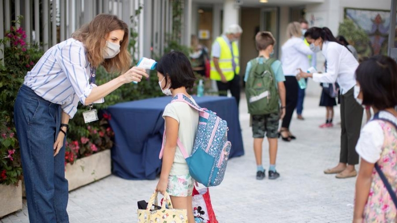 Una trabajadora toma la temperatura a una niña a la entrada del colegio privado internacional American School of Barcelona, situado en Esplugues de Llobregat (Barcelona) / EFE