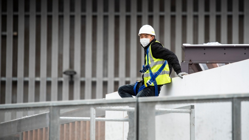 Un treballador asiàtic amb màscara en l'exterior del pavelló de l'esdeveniment Mobile World Congres  ala Fira de Barcelona. Marc González Aloma / Europa Press