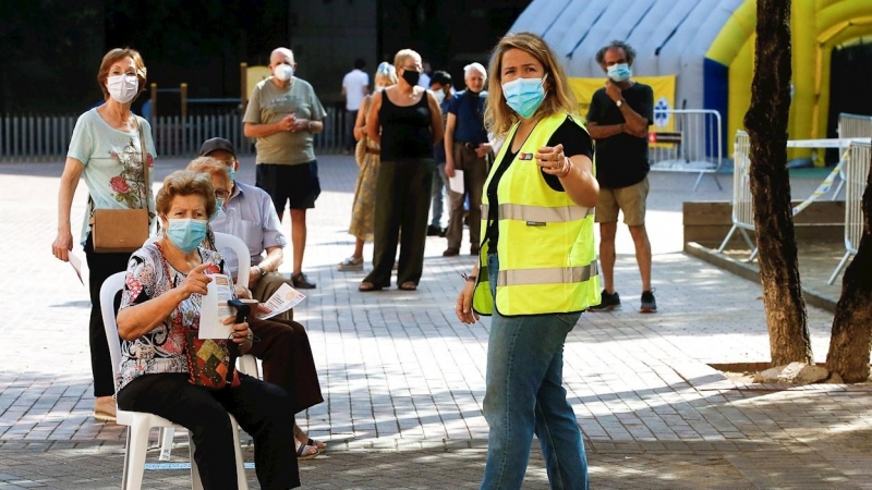 Varias personas esperan para acceder a la zona de realización de PCR durante el primer día de cribados masivos de covid-19 en El Raval de Barcelona. /EFE