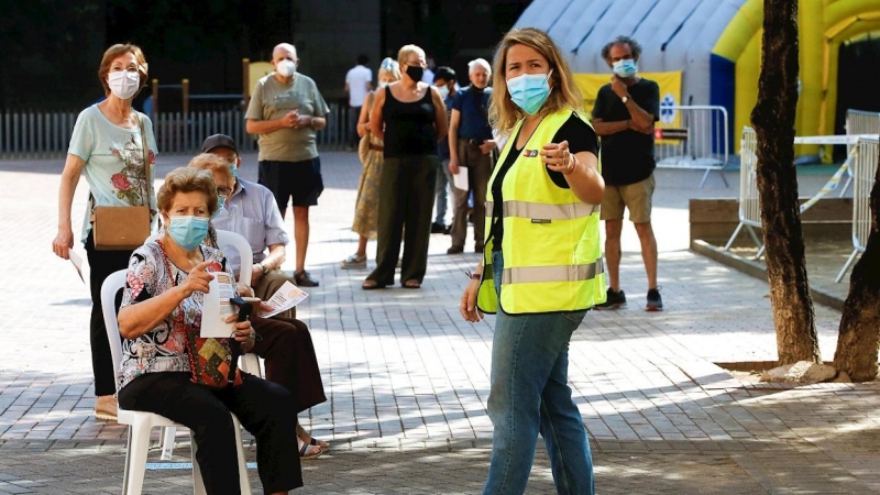 Varias personas esperan para acceder a la zona de realización de PCR durante el primer día de cribados masivos de covid-19 en El Raval de Barcelona. /EFE