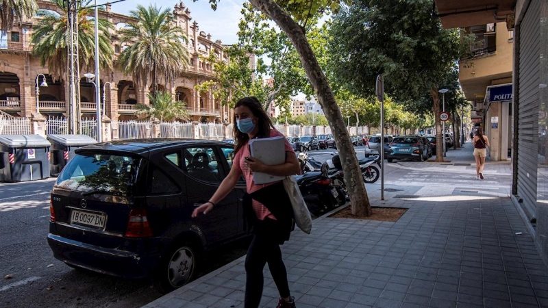 Una mujer con mascarilla camina por la avenida del Arquitecte Bennàssar en Palma, donde el Govern ha anunciado nuevas medidas para contener los contagios | EFE