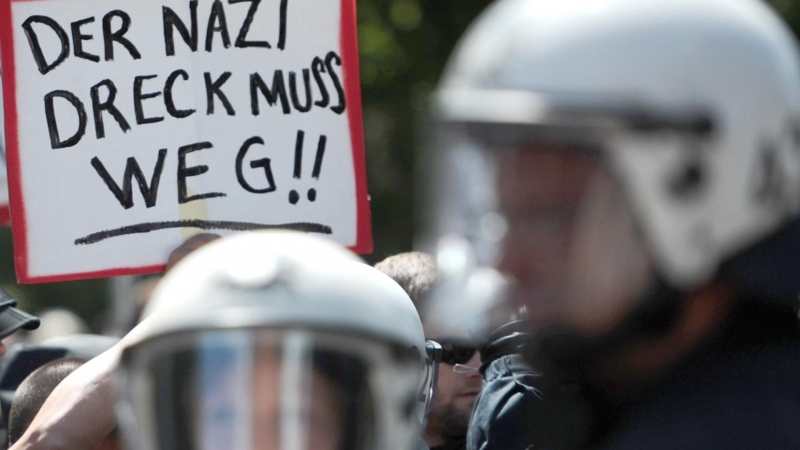 Manifestantes sostienen carteles para protestar contra una manifestación extremistas en Hamburgo. AFP / CHRISTIAN CHARISIUS