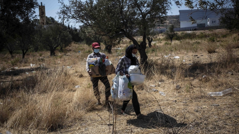 Un grupo de solicitantes de asilo camina por un sendero hacia el nuevo campo de refugiados en Lesbos / JAIRO VARGAS